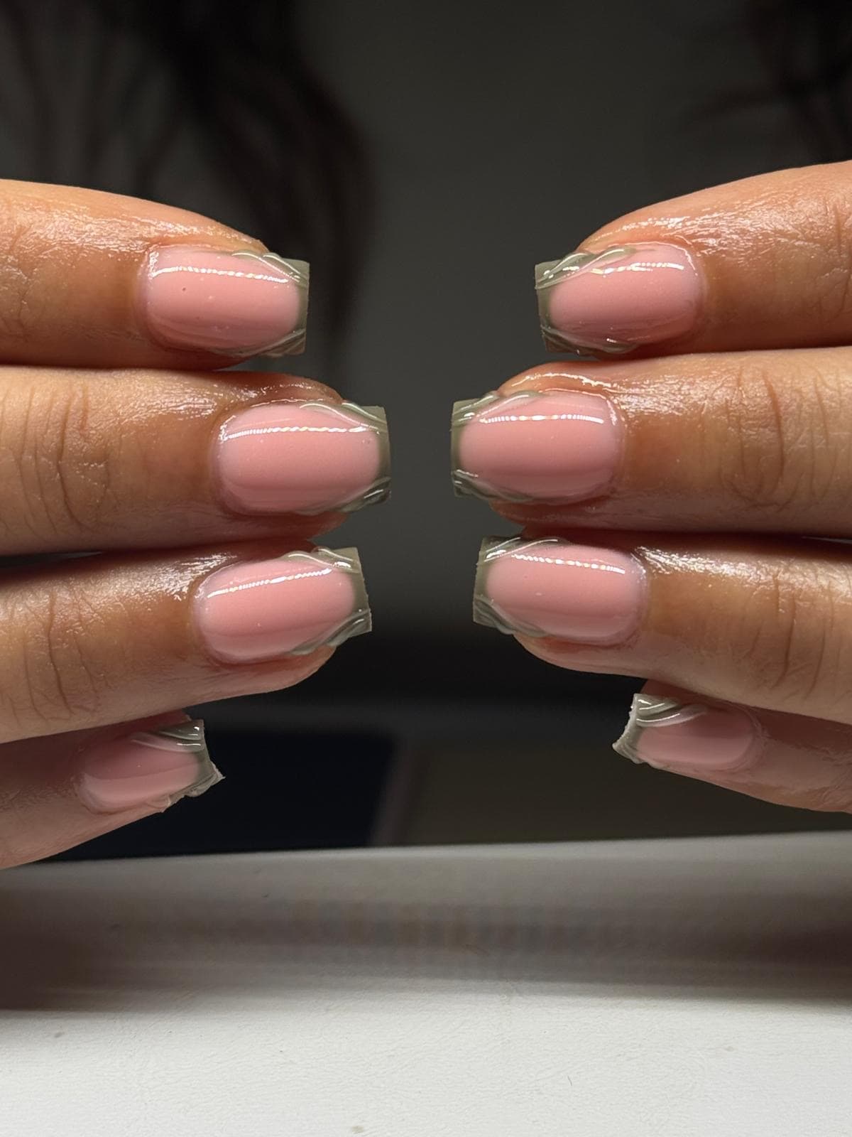 Korte vierkante gelnagels in roze met een golvende 3D gel-rand langs de tip